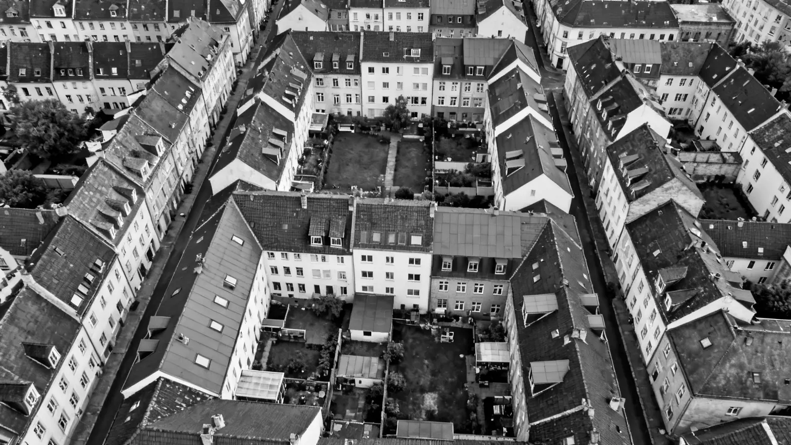 Senkrechte Luftaufnahme eines dichten Wohnblocks mit Satteldächern und Innenhöfen