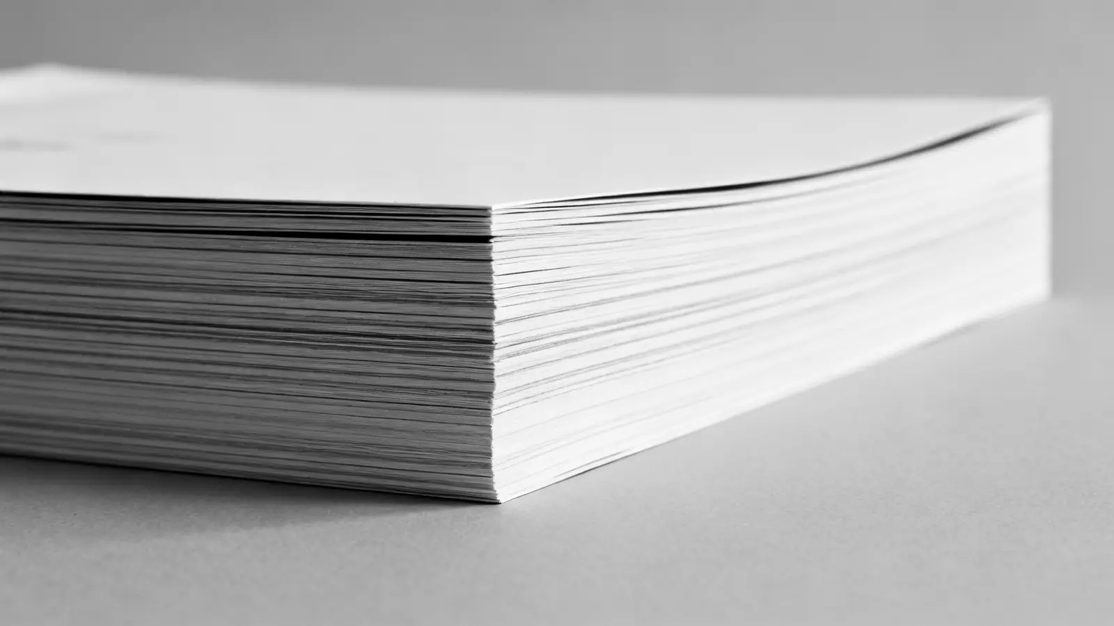 Stapel großformatiger Druckbogen von der Seite, die Papierkanten als feine Linien